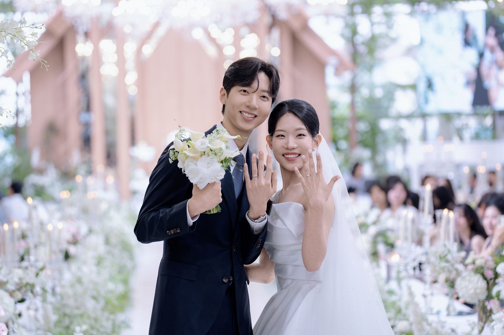 반지를 나눠 끼고 손을 들어 보이는 신랑과 신부